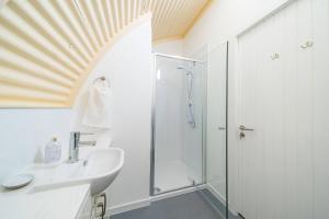 a bathroom with a shower and a sink at Cultybraggan Hut 37 in Comrie +31 photos
