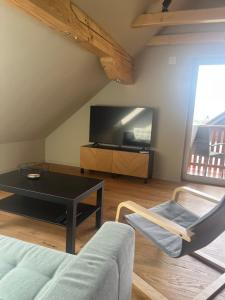 a living room with a couch and a table and a tv at Hiša Višnar in Bled