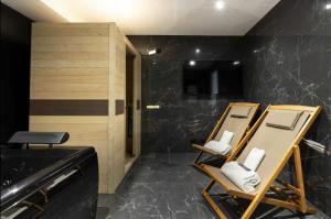 łazienka z 2 krzesłami i umywalką w obiekcie Magnifique Appartement avec Sauna et Jacuzzi w Paryżu
