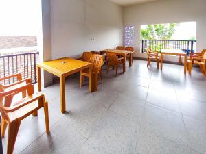 a dining room with tables and chairs on a balcony at RedDoorz Plus Syariah at Umyas Hotel near Terminal Anjuk Ladang Nganjuk in Nganjuk