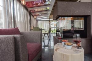 ein Zimmer mit einem Sofa und einem Tisch mit Weingläsern in der Unterkunft MOUNTAIN ALPIN Hotel Sonnleiten in Steinhaus