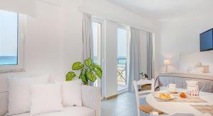 a living room with a table and a room with a view of the ocean at Aqua Marina in Rethymno Town
