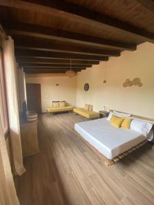 a bedroom with a large white bed and wooden floors at Dal Maestro-Camere a Rivanazzano Terme in Rivanazzano