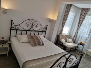a bedroom with a large bed and a chair at Family Hotel Rai in Shumen
