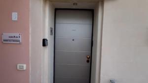 Una puerta blanca en un pasillo con un cartel. en OWNER ITALY Residence, en Torre Lapillo