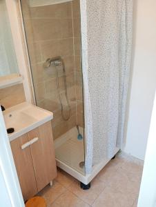 una doccia con una porta in vetro accanto a un lavandino di Le clos joli ad Argelès-sur-Mer Altre 29 foto