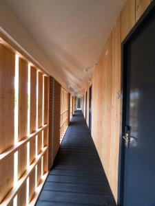 un couloir d'un bâtiment avec des murs en bois et une porte dans l'établissement Hotel Torpedoloods, à Hoek van Holland