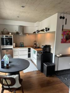 a kitchen with a table and a black refrigerator at EifelQuartier L2 in Schleiden