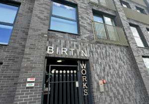 a brick building with the entrance to a brick building with a black gate at Stylish 1Bed Apartment in Sheffield CC in Sheffield