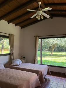 a bedroom with two beds and a ceiling fan at Cabañas Lodge el Suizo 2 in Gobernador Virasora
