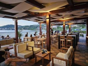 a restaurant with people sitting at tables and chairs at Del Mar Rab in Kampor