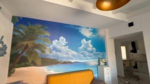 mural de una playa con una palmera en la pared en OWNER ITALY Residence, en Torre Lapillo 36 fotos más