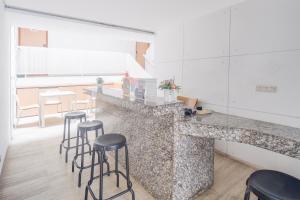 a kitchen with a counter with bar stools at Hotel O Pondok Indah Near Gandaria City Formerly Odori Residence in Jakarta