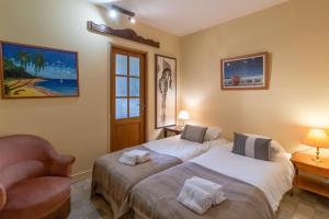 ein Schlafzimmer mit 2 Betten und einem Stuhl darin in der Unterkunft La Borie du chateau de Caudon in Domme + 18 Fotos