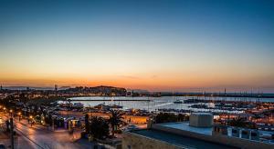 a view of a city with a harbor at sunset at Thalyra in Rethymno