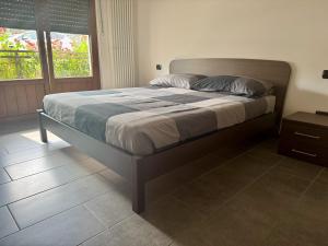 a large bed in a bedroom with a window at La Gare Apartments - Zerbion in Châtillon