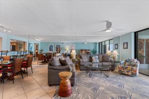 Una sala de estar con sofás y un comedor. en Beach Club Seabreeze 103, en Key West