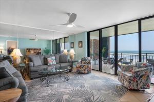una sala de estar con un sofá y sillas en Beach Club Seabreeze 103, en Key West