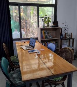 una mesa de madera con un ordenador portátil encima en Herotus Local House near Beach, en Phu Quoc