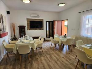 a dining room with white tables and white chairs at Del Mar Rab in Kampor