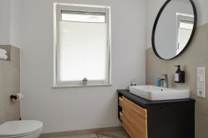un baño con lavabo y espejo en RG Living - Pro Comfort, en Bad Oeynhausen