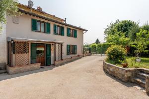 una casa con persianas verdes y entrada en L'olivo, en Capannori