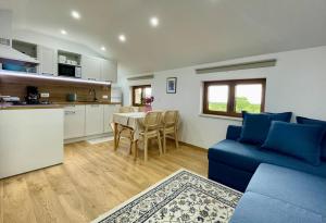 a kitchen and living room with a blue couch and a table at Vista Mare in Kaštel +23 photos