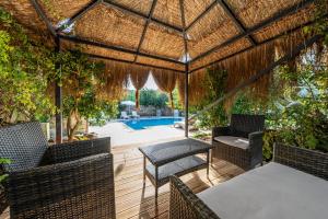 Un patio con sillas y una mesa y una piscina. en Jasmine Villa Kaya Köy, en Fethiye