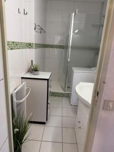 ein weißes Badezimmer mit Dusche und Waschbecken in der Unterkunft Studio tout équipé face aux thermes in Amélie-les-Bains-Palalda