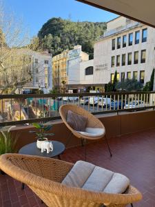 einen Balkon mit 2 Stühlen, einem Sofa und einem Tisch in der Unterkunft Studio tout équipé face aux thermes in Amélie-les-Bains-Palalda