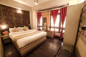 a bedroom with a large bed and a large window at Bon The Rink Heritage in Darjeeling
