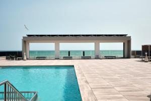 a swimming pool with a gazebo and the ocean at Residence Diana Seafront in Bibione
