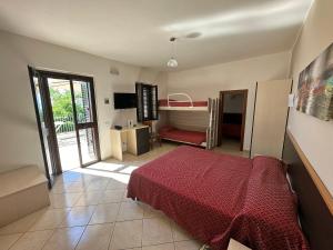 a bedroom with a bed and a desk and a bed at Hotel Normanni in Praia a Mare