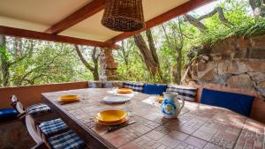 a wooden table with yellow dishes on top at Welcomely - Sa Prenda in Marinella +41 photos