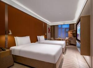Voodi või voodid majutusasutuse Beijing Temple of Heaven Crystal Orange Hotel toas