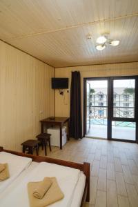 a bedroom with two beds and a desk and a balcony at Villa MARINA in Solotvyno