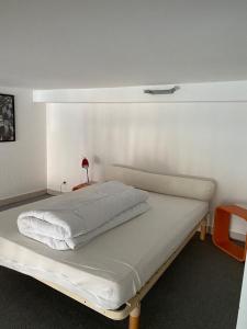 - un lit blanc dans une chambre dotée d'un mur blanc dans l'établissement Appartement Hyper Centre, à Limoges
