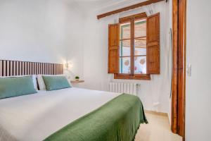 une chambre avec un grand lit blanc et une fenêtre dans l'établissement Casa Vileta, à Palma de Majorque