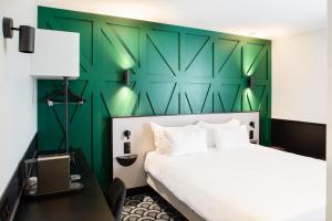 Una cama o camas en una habitación de Logis Hotel Darcy Dijon Centre