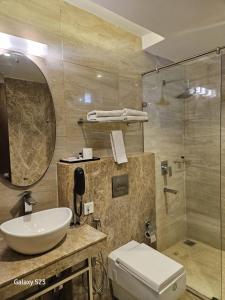a bathroom with a sink and a toilet and a shower at Hotel Ramaya in Gwalior