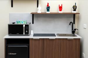 a kitchen with a sink and a microwave at Station House 45 in Naples