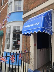 a shop with a blue awning on the front of a building at Trillberry Guesthouse in Weymouth