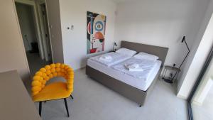 a bedroom with a bed and a yellow chair at Villa Olive in Labinci +22 photos