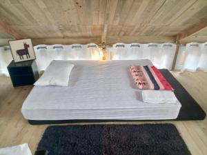 a bedroom with a bed with white sheets and white pillows at Cabaña Serenidad - Lago Atitlán in San Marcos La Laguna