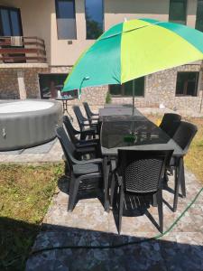 a table and chairs under an umbrella next to a tub at The Byala Escape, Private Villa with Bar & Hot Tub in Byala
