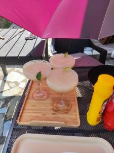 two martini glasses on a wooden board under an umbrella at The Byala Escape, Private Villa with Bar & Hot Tub in Byala