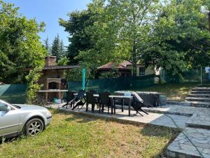 a patio with chairs and a table in a yard at The Byala Escape, Private Villa with Bar & Hot Tub in Byala
