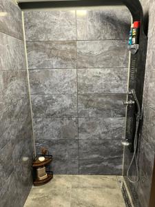a bathroom with a shower with a stone wall at The Byala Escape, Private Villa with Bar & Hot Tub in Byala
