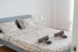 a bed with two pairs of shoes sitting on it at Canet Seaview Gem: Pool & Beach Proximity in Canet de Berenguer +26 photos