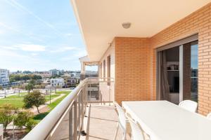 einen Balkon mit einem Tisch und Stühlen sowie Stadtblick in der Unterkunft Burriana Beach Retreat: Pool & Comfort in Burriana